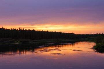 River in nature at sunset with blue sky. Landscape water beautiful concept. Long sunset over the river with bright sky and long grass in the evening. A bright evening sky and a nature long river in.