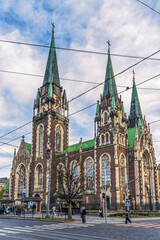 Obraz premium Vertical view of the Church of Sts. Olha and Elizabeth in Lviv. Wired lines cross out the neo-Gothic architecture and blue cloudy sky. Lviv, Ukraine - November 2, 2023