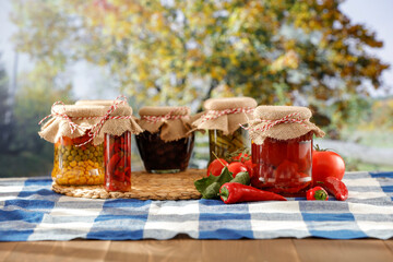 Pickled vegetables on wooden kitchen table with moody sunny autumn background.