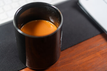 Black Mug of Coffee on Wooden Office Desk