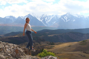 Hiker woman on top Aktash Altai mountains. Scenic view and snowy tops on background.