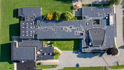 Aerial photo solar panels install on a flat commercial, school, industrial roof.	