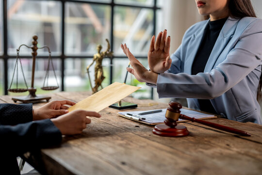 Lawyer rejecting bribe from businesswoman with stop gesture