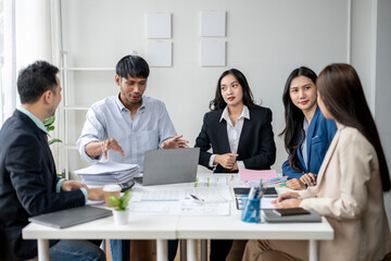 A group of people are sitting around a table, working together on a project