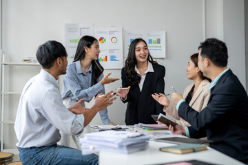 A group of people are sitting around a table in a conference room