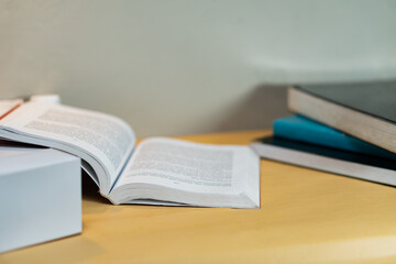 Open Book on Desk with Stacked Books in Background