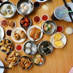 Traditional Chinese dim sum in metal bowl on wooden table. A lot of different kinds of food and...