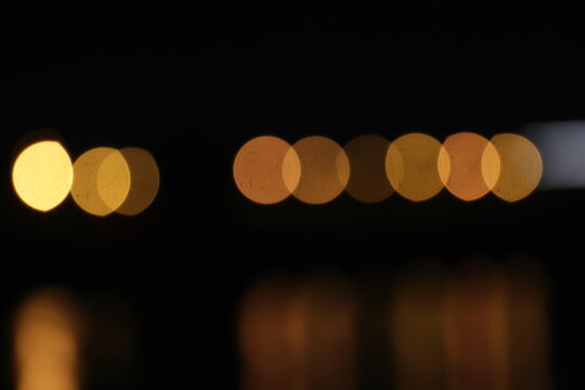 A blurred city street image at night. Abstract blur urban city street road with lighting bokeh for background.