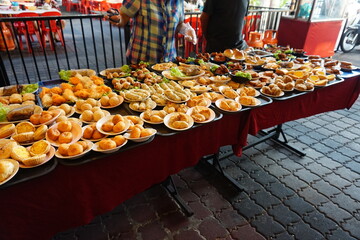 Traditional Chinese dim sum in metal bowl on wooden table. A lot of different kinds of food and...