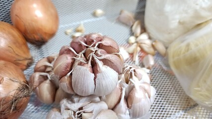 Garlic and onion in plastic bag for sale at local market. Garlic in the market. Selective focus and shallow depth of field.