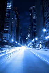 Obraz premium A stunning night view of a bustling city street, illuminated by blue tones and glowing lights.