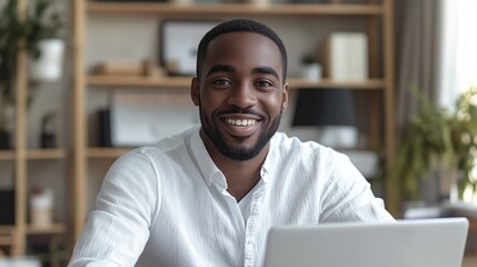 Obraz premium Portrait of smiling man sitting at desk with laptop looking in camera