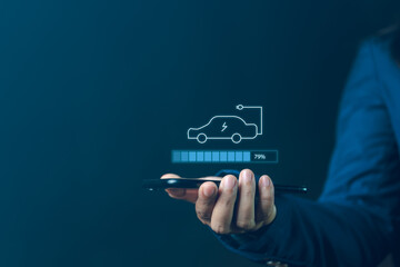 Businessman Holding Smartphone Displaying Electric Car Charging Status Highlighting Renewable...