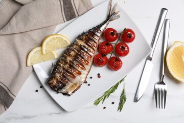 Delicious grilled mackerel, tomatoes, peppercorns and lemon served on white marble table, flat lay