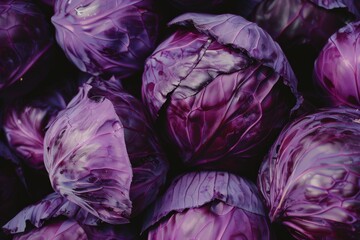 Obraz premium A cluster of deep purple cabbages nestled together, their vibrant hues highlighting the natural patterns of their leaves.