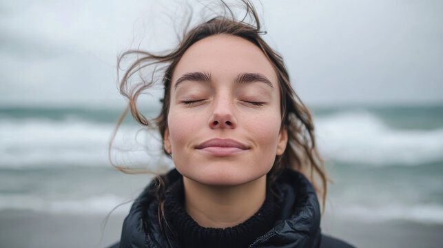 visage de femme les yeux ferm&eacute;s respirant l'air marin en bord de mer