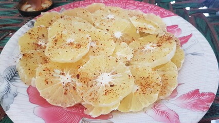 A white plate featuring orange slices and a green garnish on a black countertop food, meal, plate, cheese, dish, fried, dinner, baked, sweet, fish, white, chicken, delicious, High quality HD 4K video 