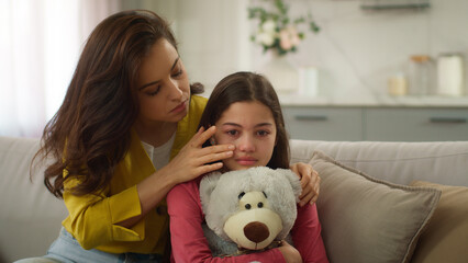 Worried Caucasian parent woman feel guilty female mother apologizing ask forgiveness little girl after quarrel argument calming sad child hugging saying sorry to crying kid daughter indoor living room