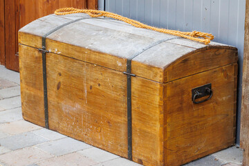 A large, simple wooden chest with black, unadorned iron fittings