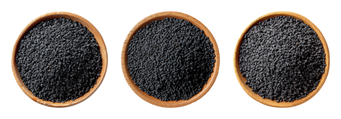 Black cumin seeds displayed in three wooden bowls, showcasing their rich color and tiny, teardrop shape