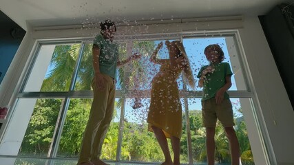 A pregnant woman, her husband, and their elder son conduct a gender reveal party. They blow up a big black balloon, see pink confetti, and start jumping and cheering excitedly as they discover they