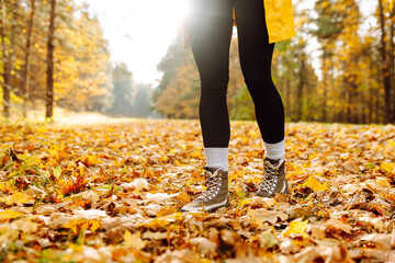 Exploring autumn trails in sturdy boots surrounded by colorful fallen leaves in a vibrant forest setting. Enjoying a beautiful autumn day outdoors in the forest.