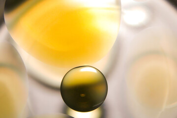 Golden circular oil bubbles floating on a clear water background.