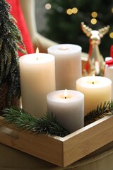 Tray with burning candles and Christmas decor on blurred background, closeup