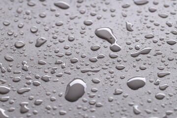 Water drops on gray background, closeup view