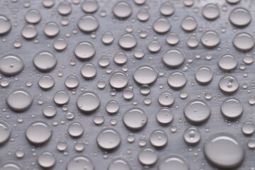 Water drops on gray background, closeup view