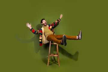 Photo of handsome cheerful man wear trendy clothes sit chair wow offer isolated on khaki color...