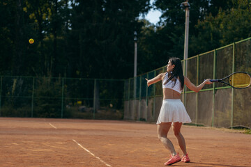 Obraz premium Young woman playing tennis outdoor at summer