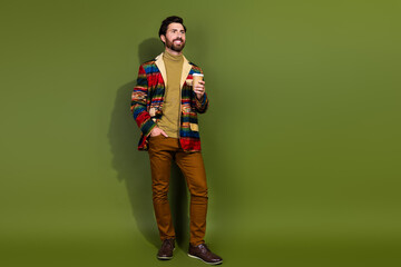 Fototapeta premium Photo of nice positive man dressed stylish clothes drink coffee empty space isolated on khaki color background