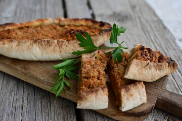  Traditional Turkish cuisine. Baked Pide dish with chicken ,  cheese and  herbs on  wooden background.  Turkish pizza pide