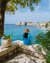 A young Asian woman sitting peacefully near the coast, a visitor enjoys panoramic views of...