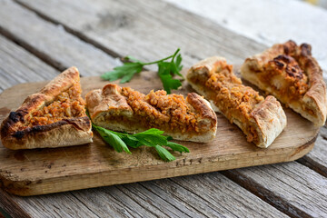  Traditional Turkish cuisine. Baked Pide dish with chicken ,  cheese and  herbs on  wooden background.  Turkish pizza pide
