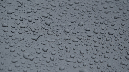 Tropfen bei Regenwetter auf einer sauberen, gut gepflegten und polierten nassen Auto Lackierung in der Farbe metallic Grau, Lackpflege beim Auto, Lotuseffekt