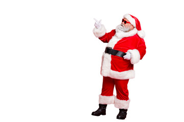 Full length profile side photo of charming santa claus in eyewear eyeglasses  showing promo wearing bright costume belt isolated over red background