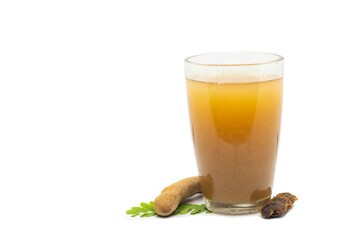 Ripe Tamarind or Imli Fruit Sharbat Water or Juice in a Glass with Leaves Isolated on White Background with Copy Space