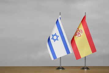Table flags of Israel and Spain on a gray blurred background