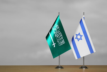 Table flags of Israel and Saudi Arabia on grey blurred background