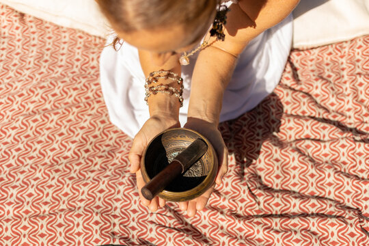 young woman playing a Tibetan singing bowl