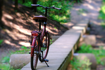 A beautiful bicycle resting on a wooden path, surrounded by a lush green forest landscape