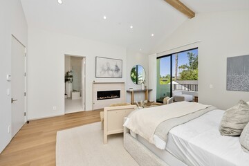 Modern bedroom with fireplace and large window