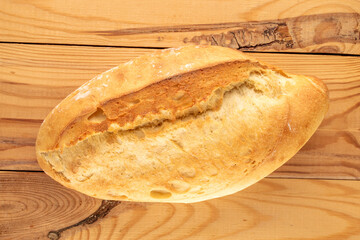 One white bread on a wooden table, macro, top view.