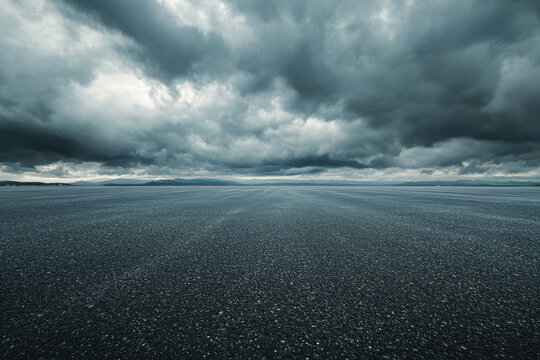 Empty asphalt road covered with rain drops under dramatic sky
