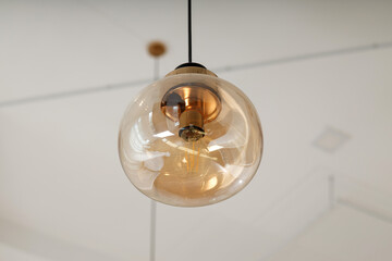 Modern pendant lights with clear glass shades hanging in a minimalist room interior