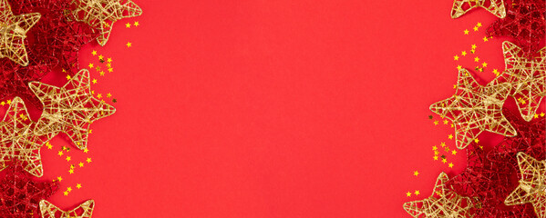 Christmas holiday background. Merry Christmas poster. Holiday background with Christmas decorations with gold and red glittering stars on red background, banner, advertising space.