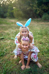 two little girls hug and play bunnies on  Easter egg hunt