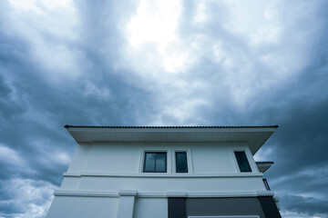 The contemporary home is framed by a gloomy, nearly cloudless sky that seems ready to pour.